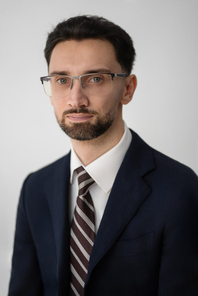 Man in glasses posing for a corporate headshot in New Jersey with minimal lens glare