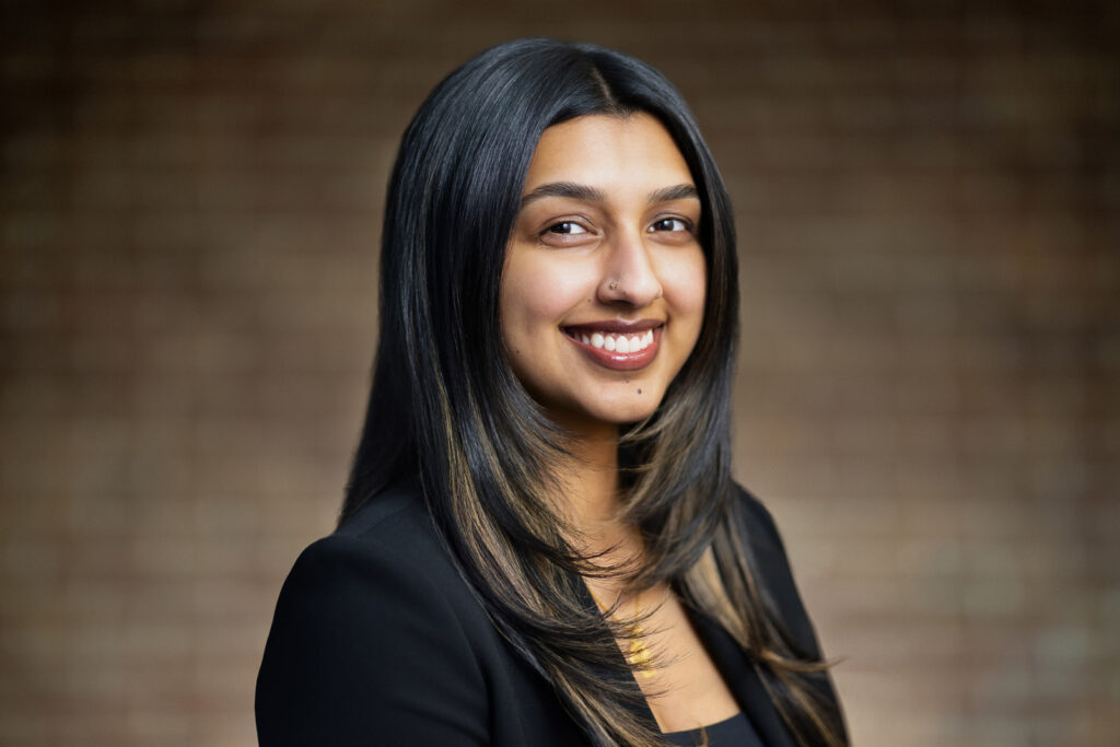 Young woman in black blazer with confident bright smile during LinkedIn headshot session in NJ studio