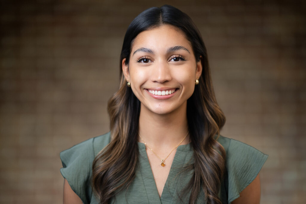 Young woman in sage green top with warm natural smile during modern business portrait session in NJ