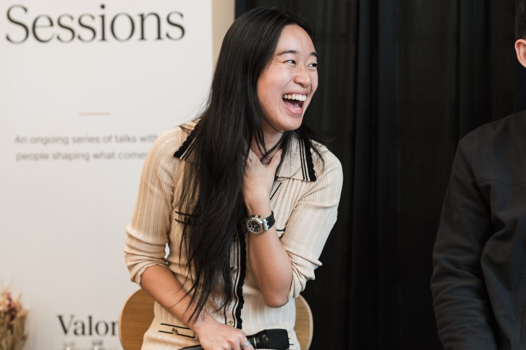 Panelist laughing beside the Valon Sessions banner during the corporate leadership panel