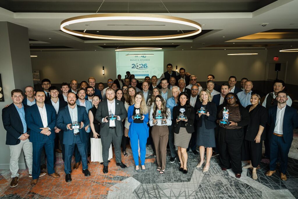 RMR Wealth team holding robot trophies at a corporate summit at MC Hotel in Montclair NJ