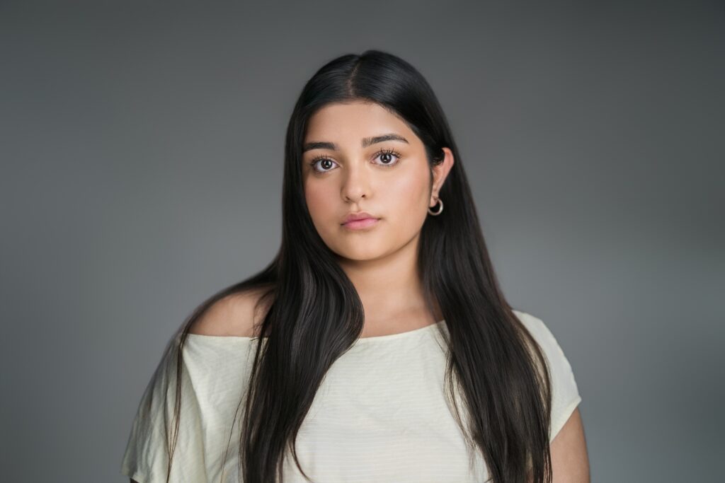 Young professional posing for a clean studio headshot on a neutral backdrop