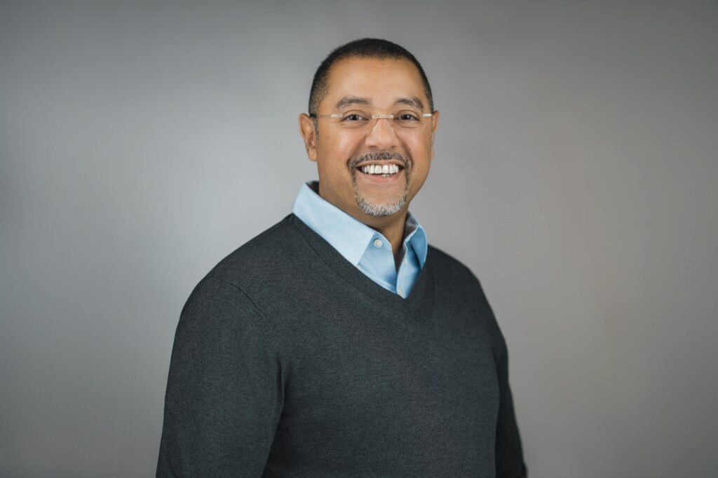 Business professional smiling in a gray sweater during a LinkedIn headshot session in New Milford NJ