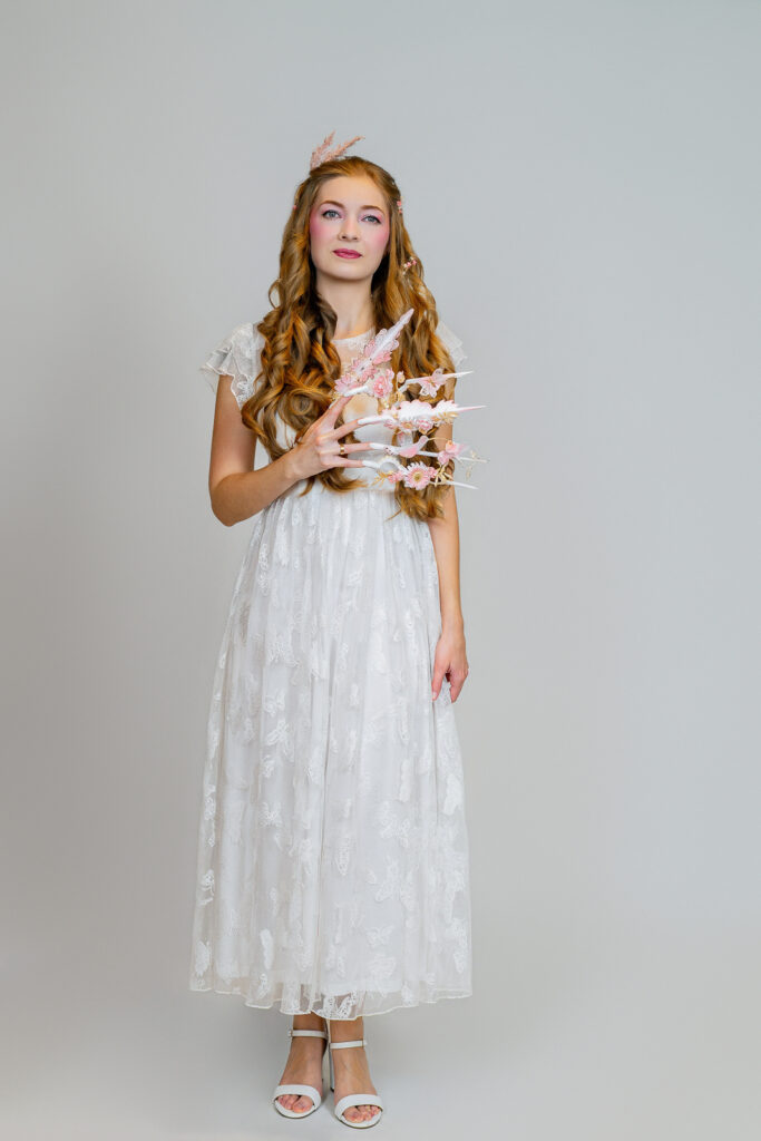 Close-up of hand-sculpted floral nail art photographed against black in a New Jersey studio
