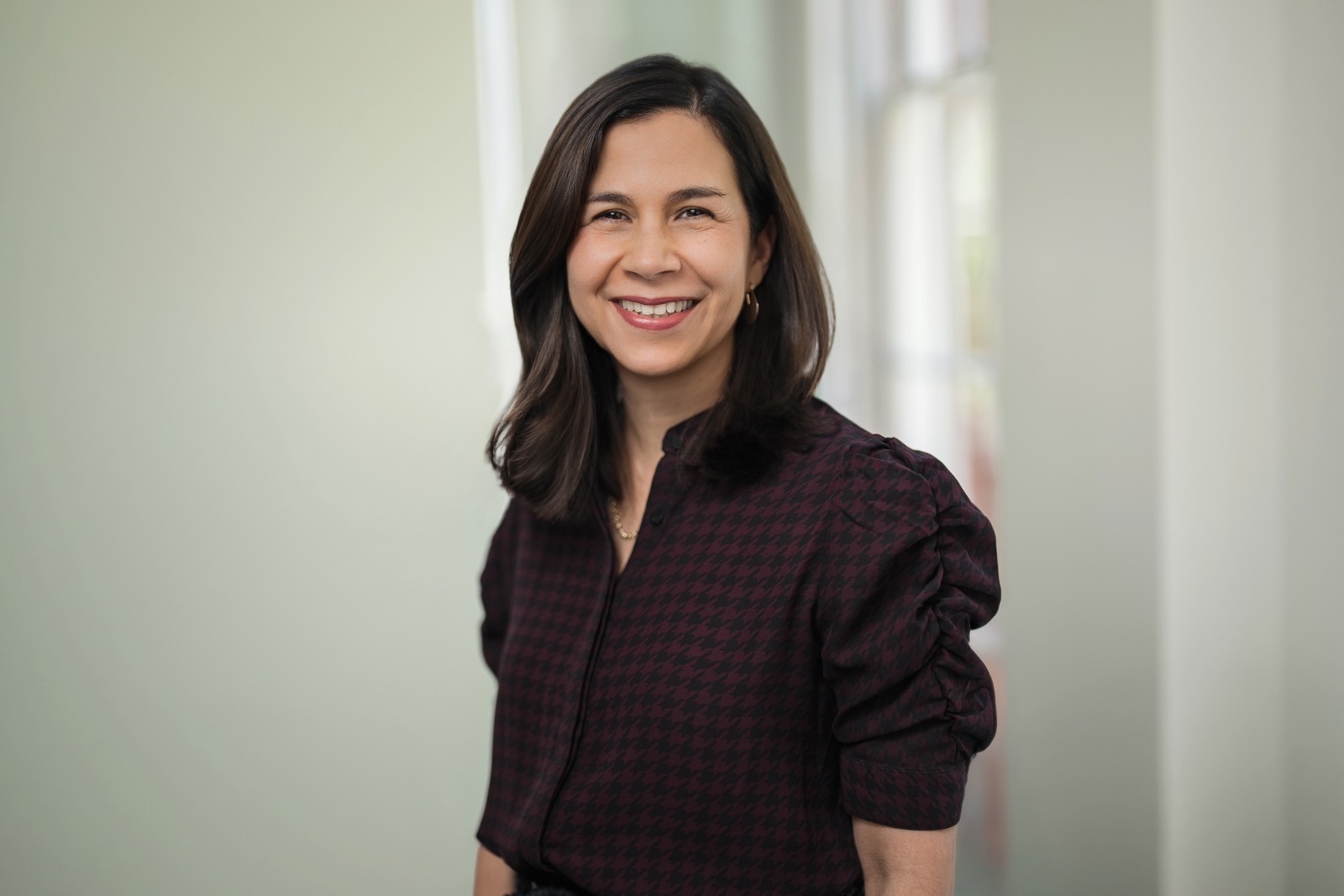 Smiling executive during a professional headshot session photographed by Alex Kaplan in a sunlit office