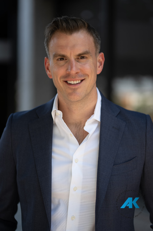 Financial advisor smiling during an outdoor executive headshot session in Hackensack, New Jersey.