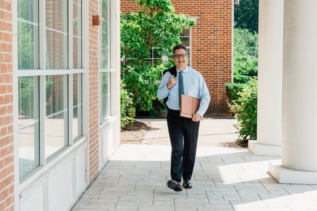 Attorney walking through open shade during an outdoor corporate headshot session in New Jersey