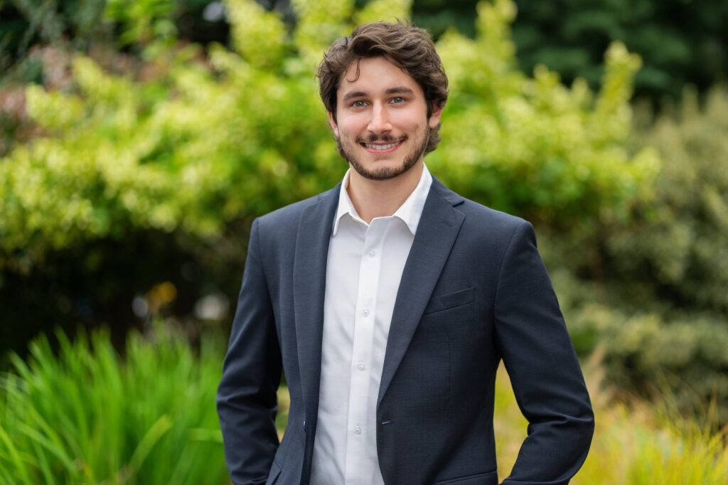Business professional photographed outdoors against green foliage in Northern New Jersey