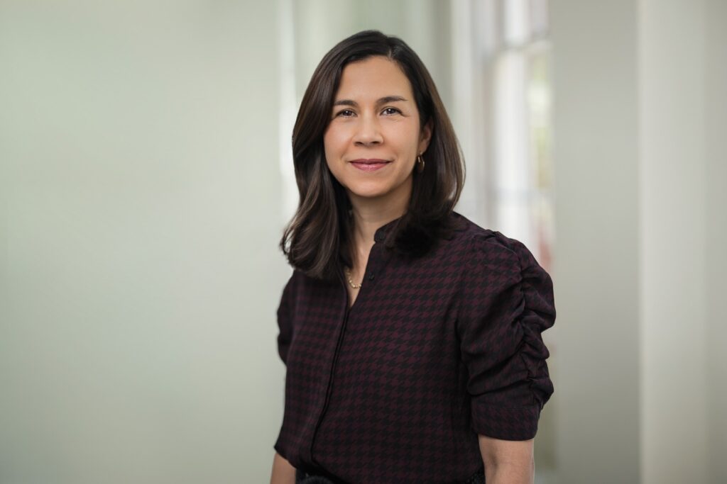 Confident executive with a soft smile during an executive headshot session in a bright office