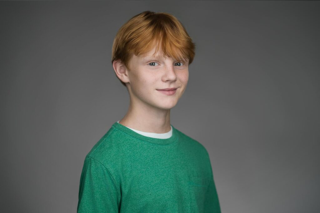 Young actor turned slightly from camera in layered knit top during New Milford NJ headshot session