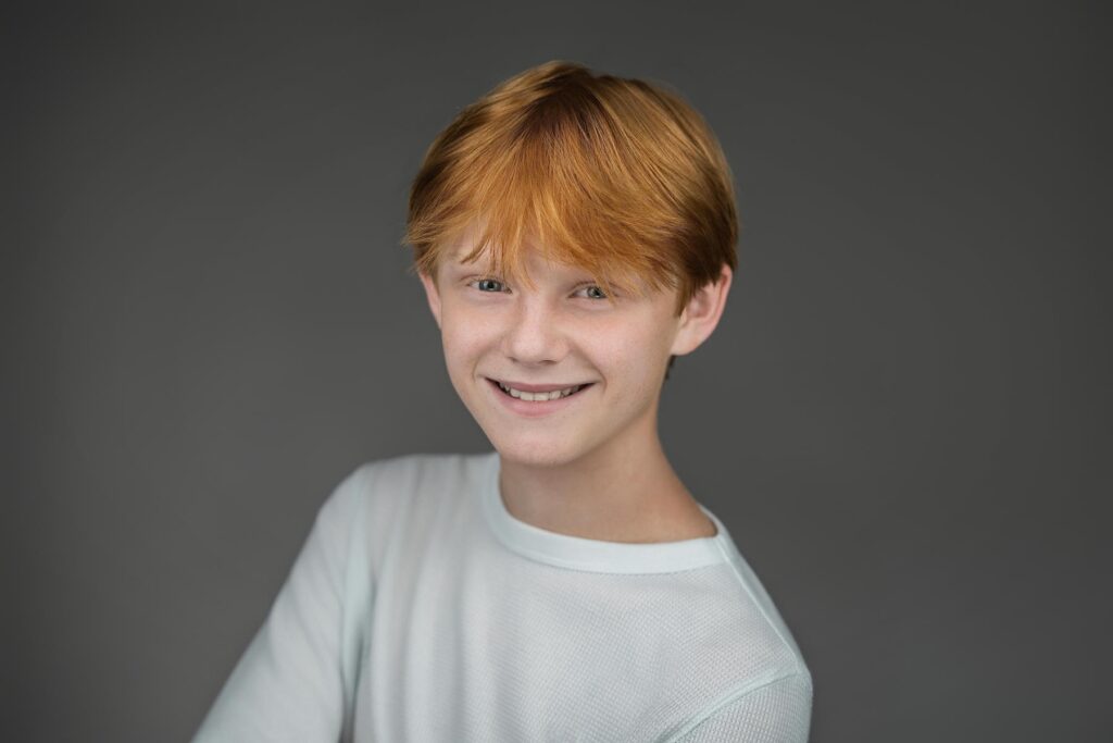 Young actor smiling at an angle in waffle knit top during New Milford NJ headshot session