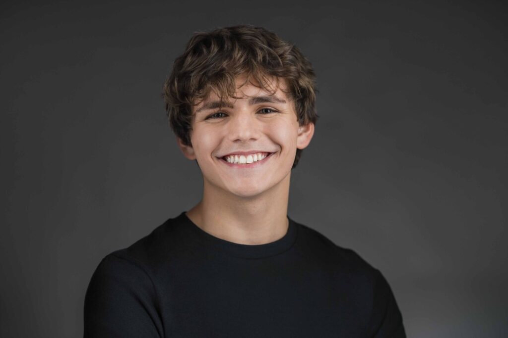 Commercial style smiling headshot on a dark grey backdrop, New Milford NJ studio