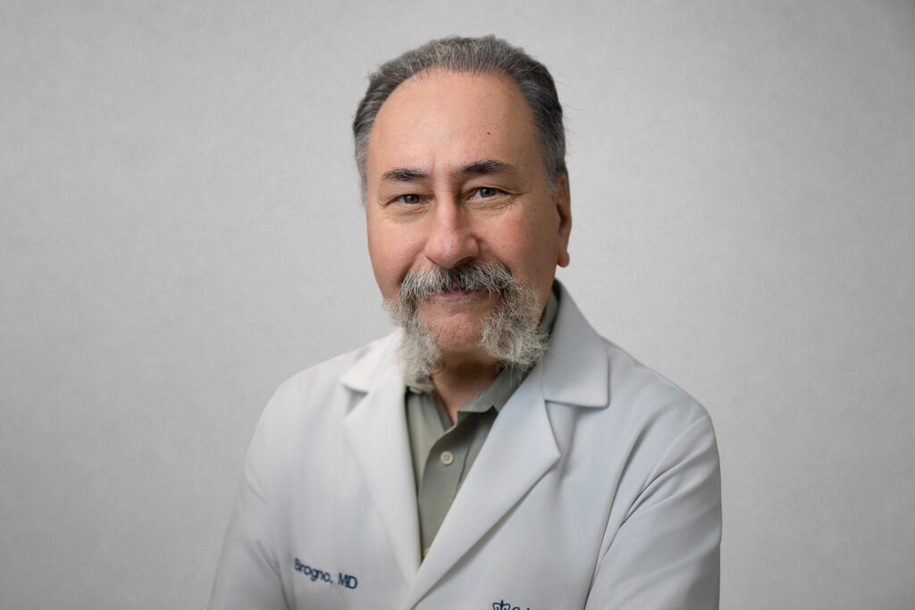Bearded doctor in a white coat photographed for consistent doctor headshots in Yonkers NY 