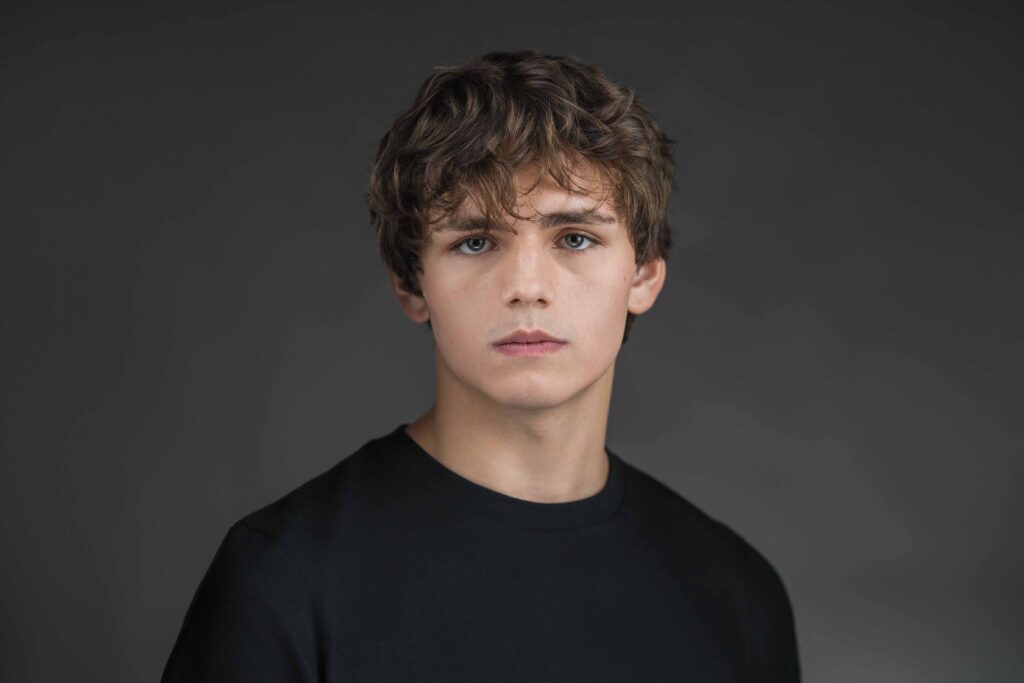 Young professional posing with a neutral expression at a New Jersey studio