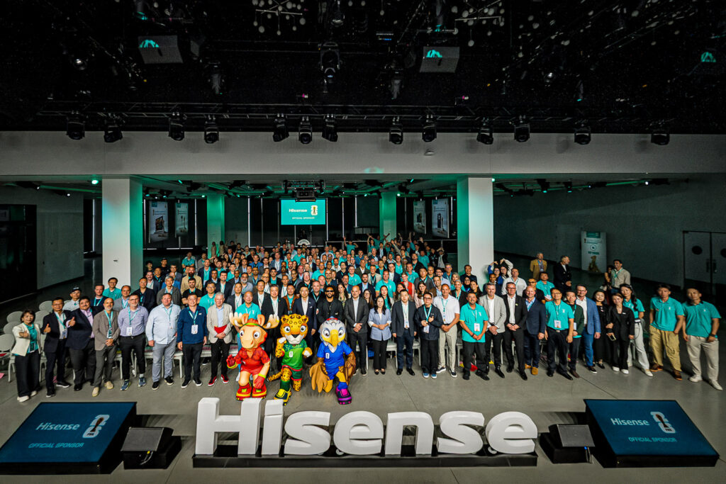 Conference attendees posing for a large group photograph at The Glasshouse