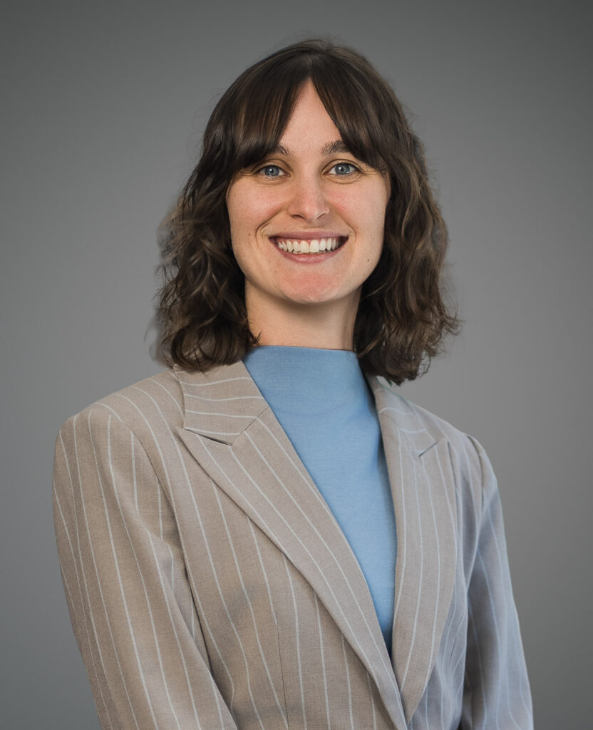 Professional woman smiling during LinkedIn headshot session against a clean studio background