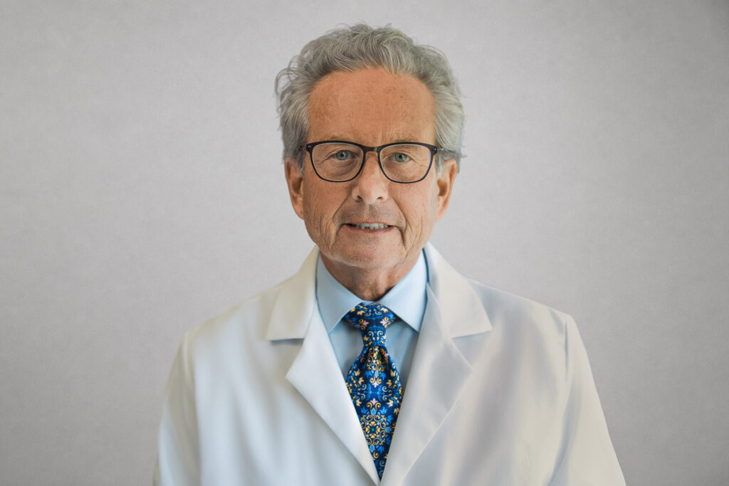 Physician in a white coat and tie photographed for medical professional headshots in New York