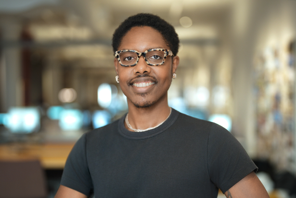 Employee photographed against a softly blurred working office background in New York City