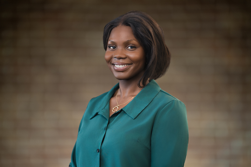 Professional in a green blouse showing how background tone separates a subject in a headshot