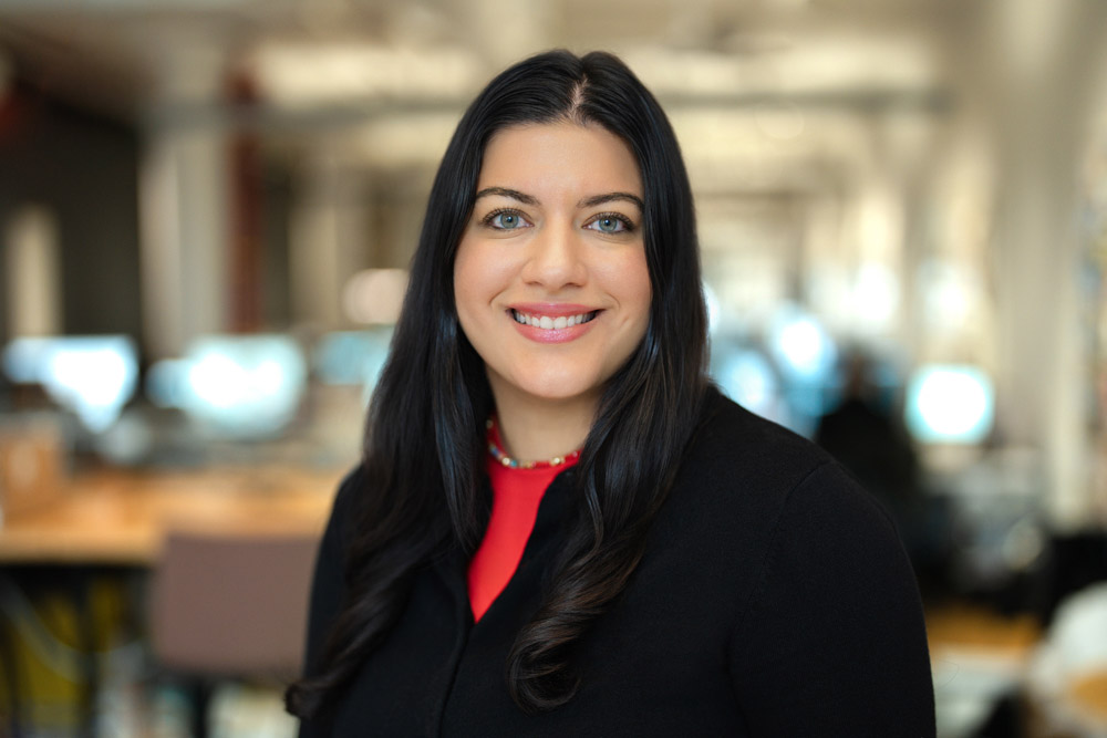 Employee in a dark blazer photographed against a softly lit New York City office