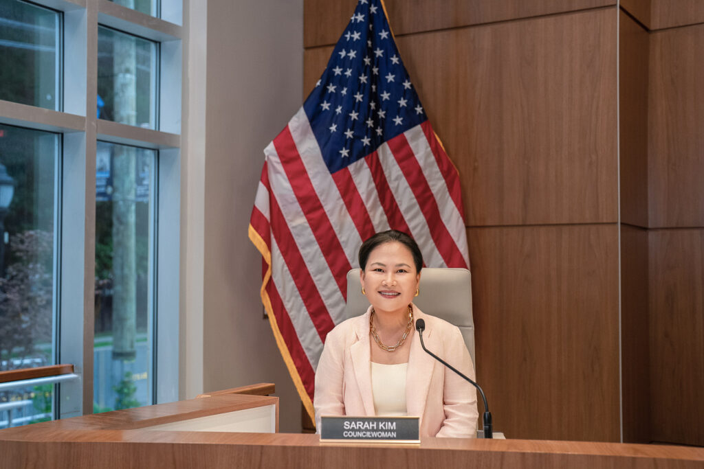 Council candidate seated at the dais with an American flag in Ridgefield New Jersey 