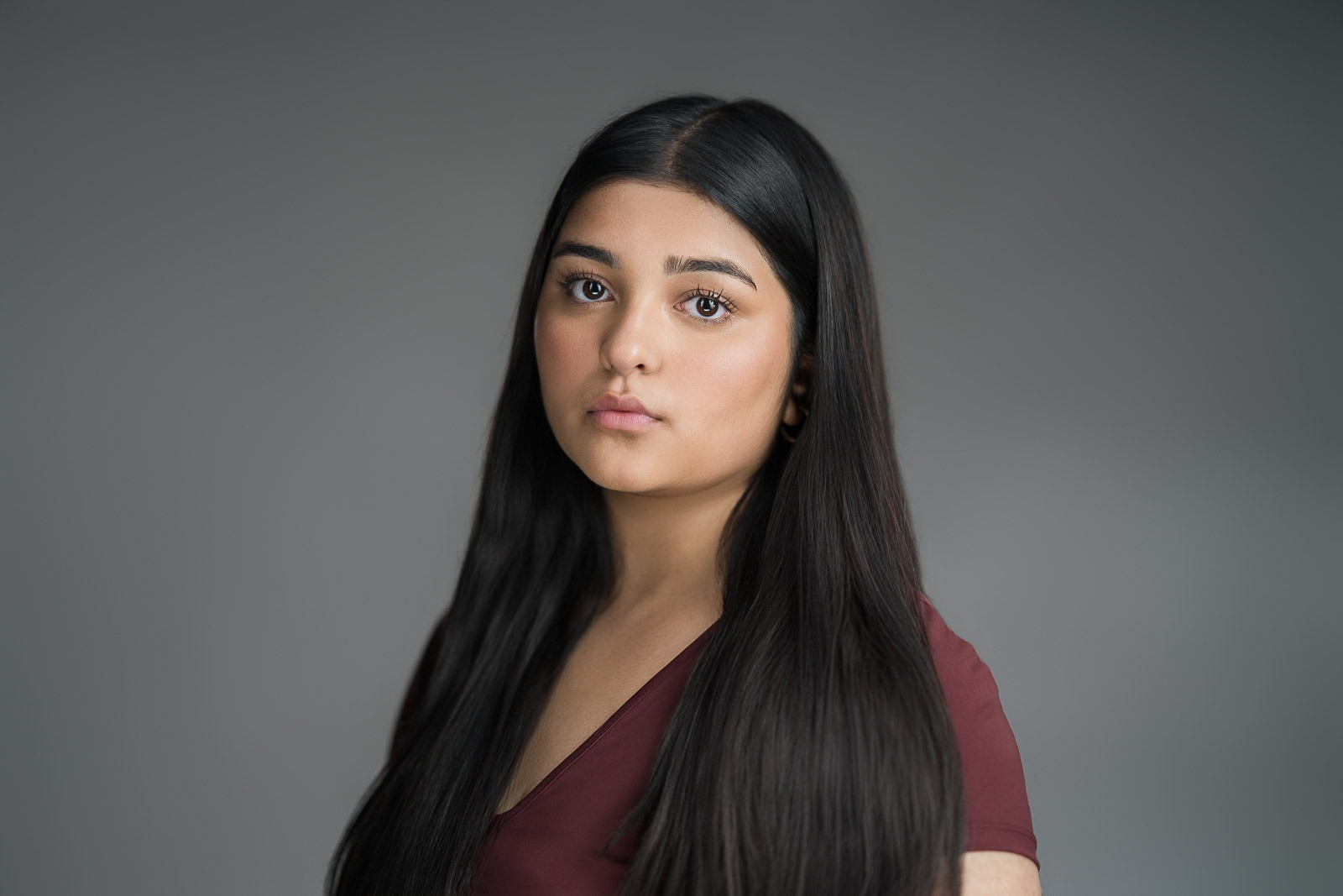 Headshot showing natural skin texture on a grey backdrop in New Milford NJ