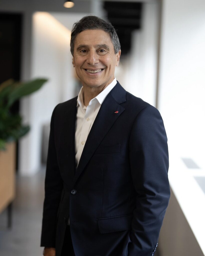 Business executive smiling during a professional headshot session in a modern office corridor