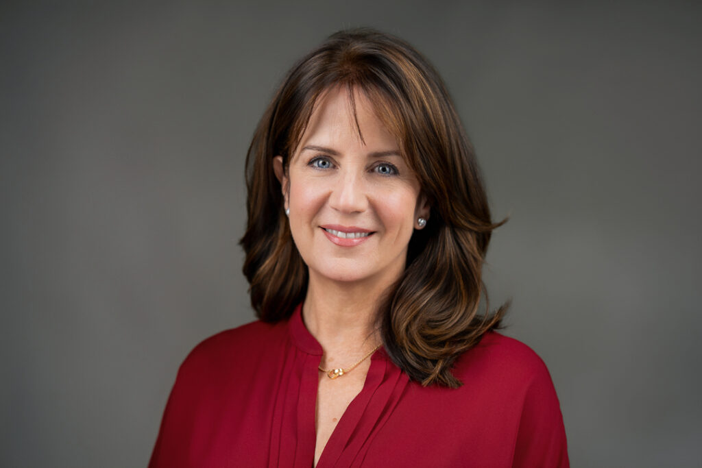 Professional woman smiling warmly during a professional headshot session in a New Jersey studio
