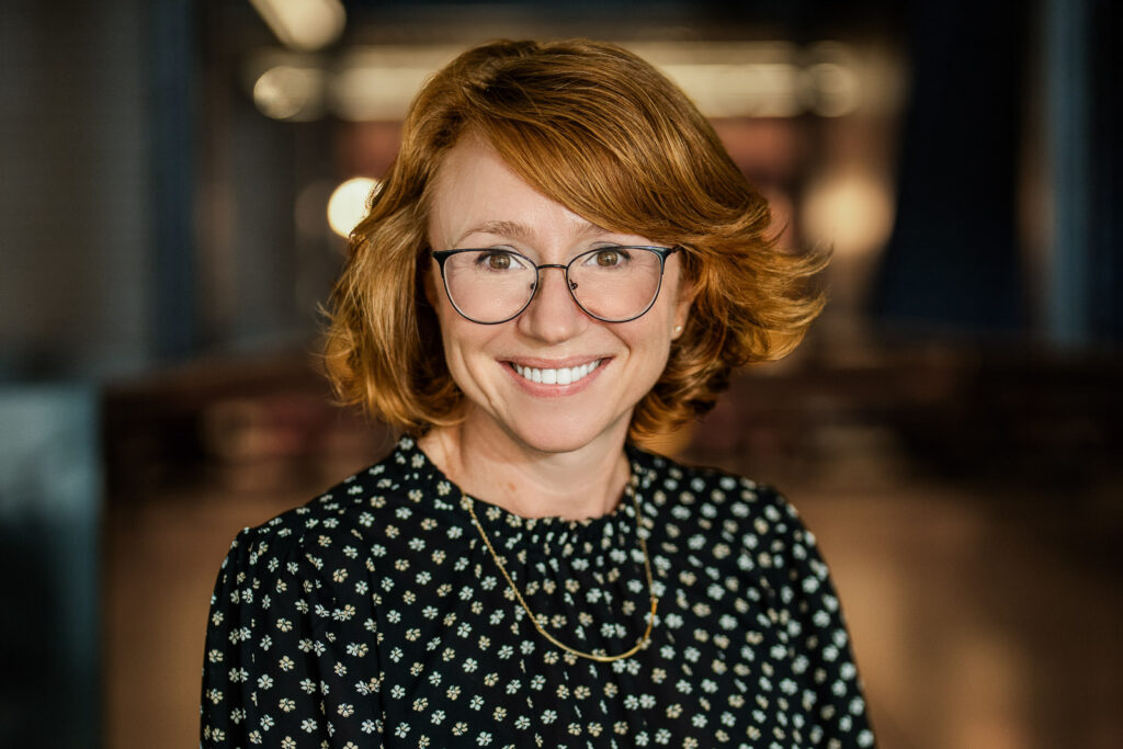 Woman wearing glasses smiling during a professional headshot session in New Jersey