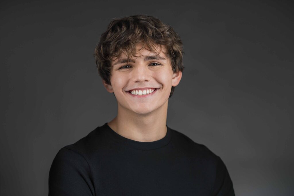Young professional smiling during a headshot session at a New Jersey studio