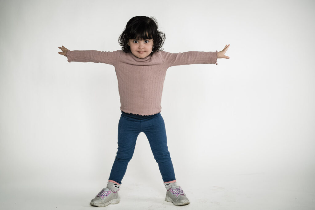 Preschool girl in a full-length child actor photo on white background