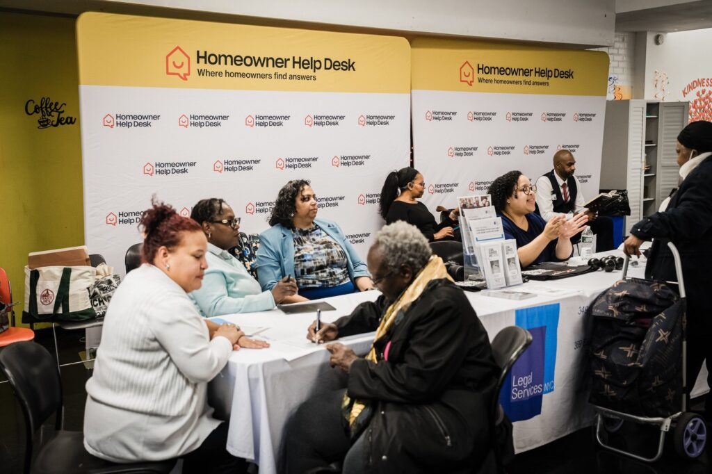 Advisors meeting one-on-one with visitors at tables during the Bronx Homeowner Help Clinic