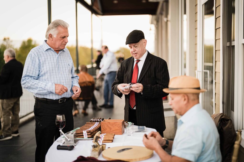 Guests gathered at the cigar station on the terrace during the Tilcon corporate event