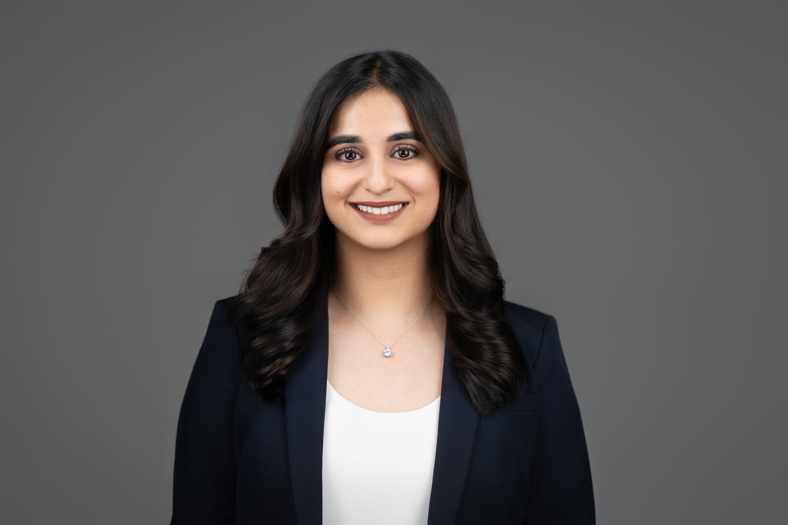 Smiling woman in navy blazer posing for ERAS style headshot in New Jersey studio