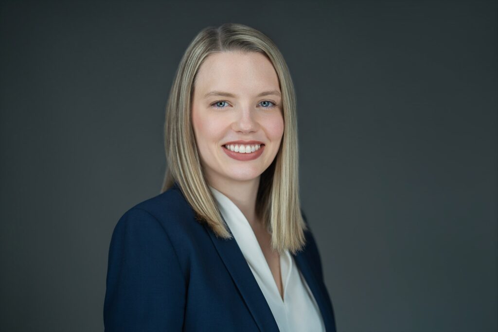 Smiling woman in navy blazer and white blouse at headshot studio in New Milford, NJ