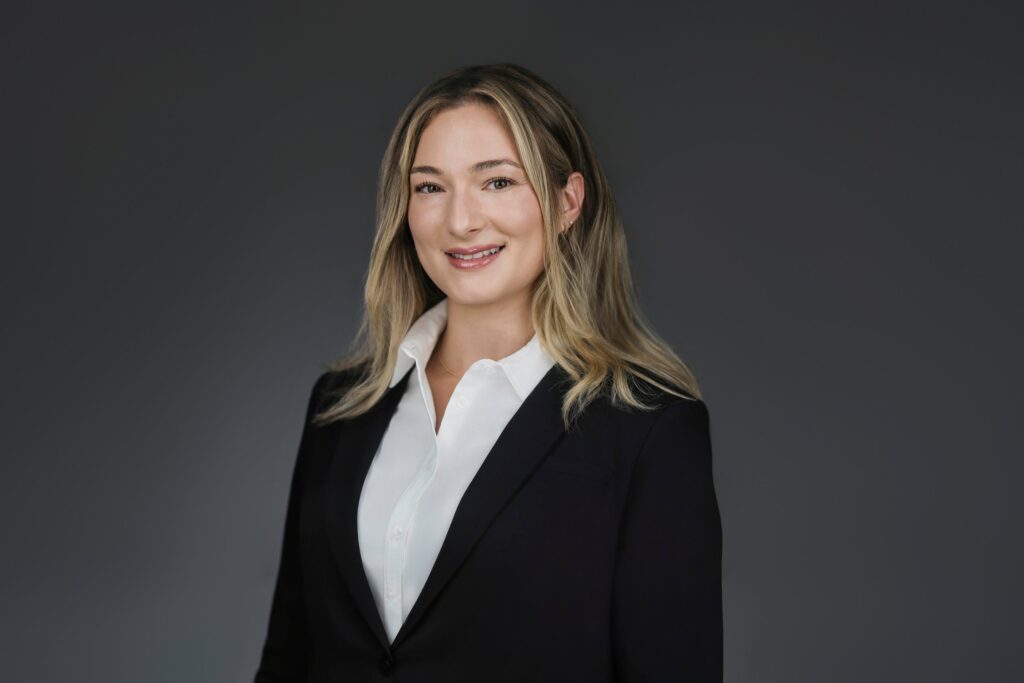Professional headshot with a white collared shirt and black blazer, one of several wardrobe options