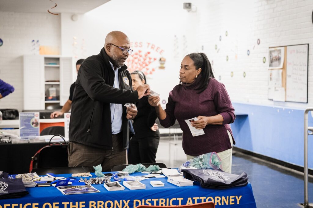 Community organization representatives engaging with attendees at a Bronx outreach event