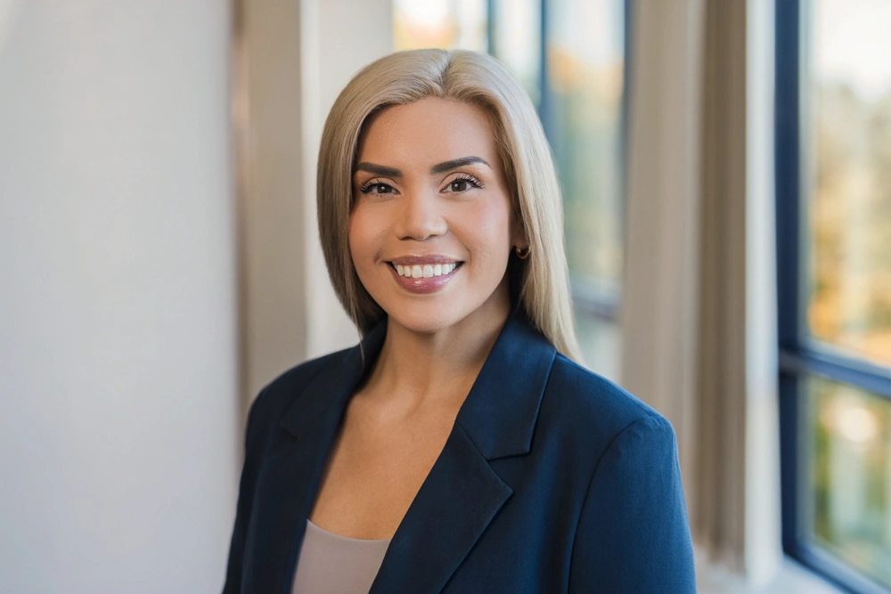 Professional wealth management team member smiling in a navy blazer