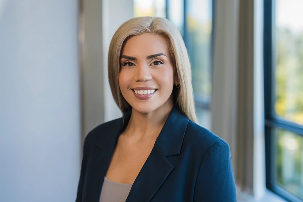 Professional wealth management team member smiling in a navy blazer