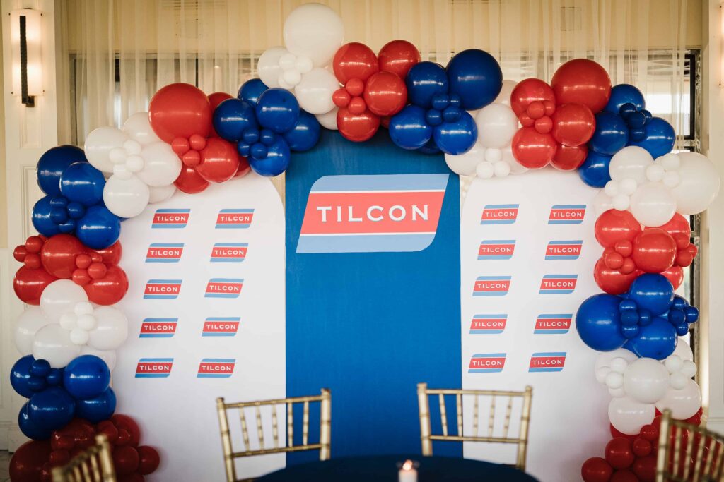 Red, white and blue balloon arch around the Tilcon logo at the Liberty House corporate event